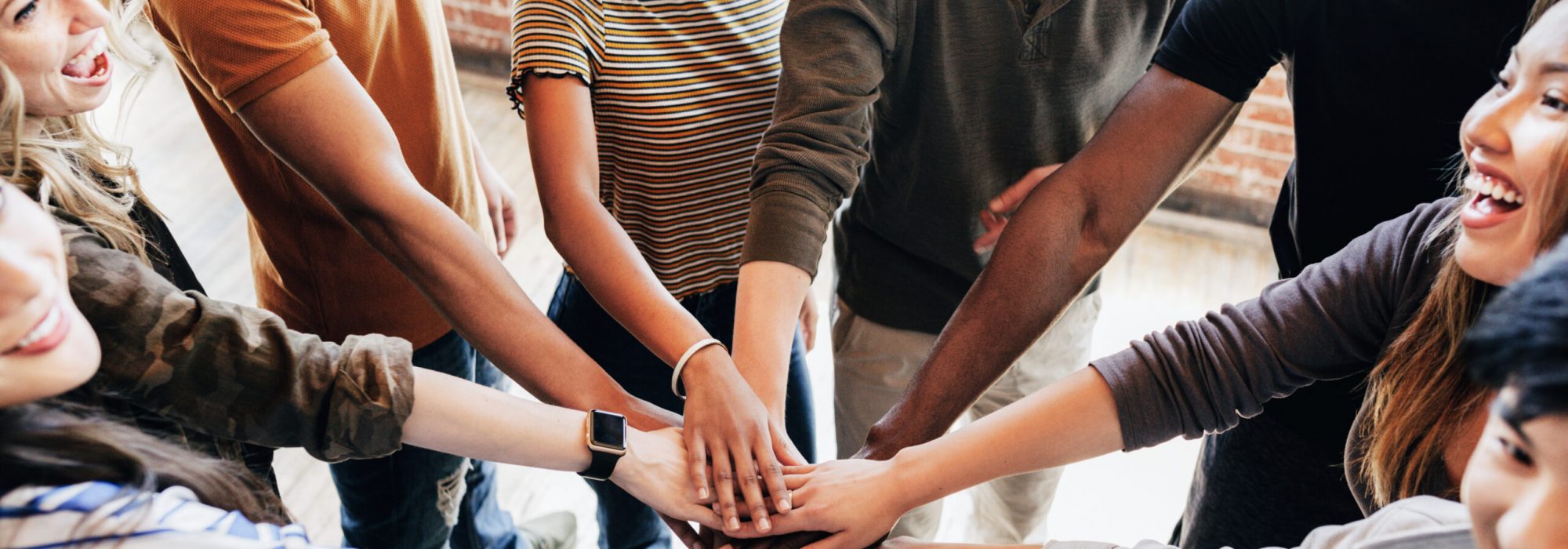 Group of diverse people stacking hands in the middle